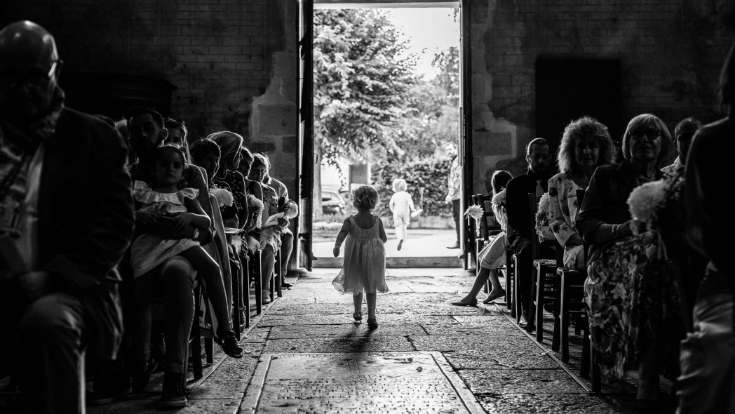 une petite fille sortant d'une église à contre jour